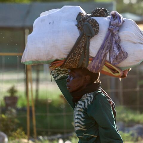 A woman carries her belongings as she flees amid fighting between the army and paramilitaries in Khartoum on April 19 