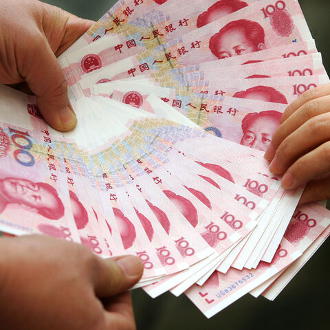 A Chinese vendor displays notes during a cash transaction in Beijing 14 January 2007. The yuan was pegged to the US dollar until 2005 when Beijing decided to revalue it by 2.1 percent and place the unit in a currency basket, allowing a greater but still very tightly controlled margin of flexibility, but the yuan has since slowly but steadily risen in value on the back of China's booming economy and the breaching of the 7.80 level. AFP PHOTO (Photo credit should read STR/AFP via Getty Images)