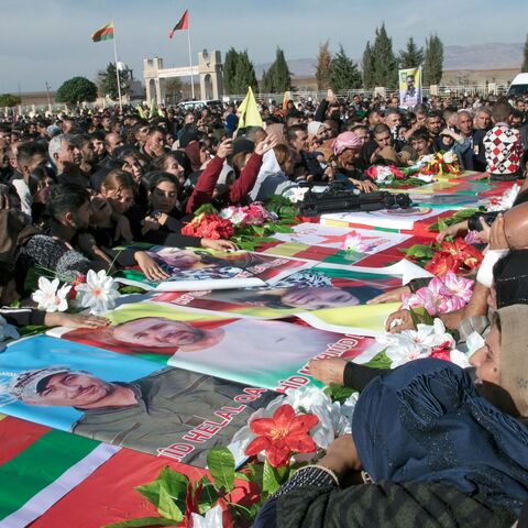 Relatives mourn over the caskets of 11 people killed in Turkish airstrikes.