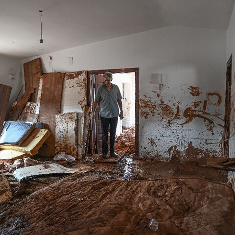 A man inspects a mud covered room in a house in the eastern Libyan city of Susa