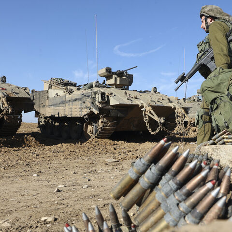An Israeli soldier walks next to an armed APC (Armed Personnel Carrier) in southern Israel near the border with the Gaza Strip on November 30, 2023, as a truce between Israel and Hamas enters its seventh day. A truce between Israel and Hamas was extended on November 30 just before it was due to expire, the two sides announced, with mediator Qatar reporting it would continue for one day under the same conditions that saw hostages released in exchange for prisoners. (Photo by GIL COHEN-MAGEN / AFP) (Photo by 
