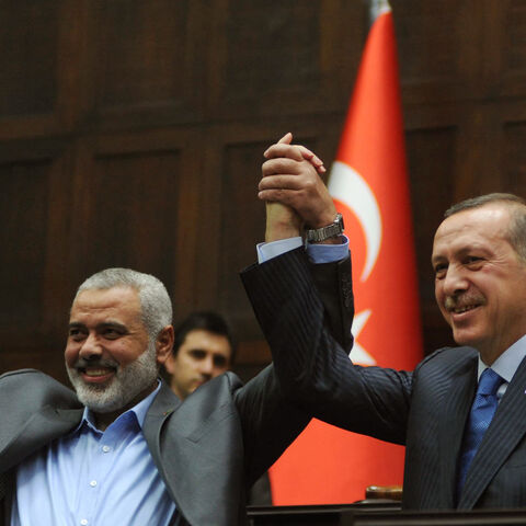The Gaza Strip's Hamas Prime minister Ismail Haniya (L) and his Turkish counterpart Recep Tayyip Erdogan salute together the lawmakers of Erdogan's Islamic-rooted Justice and Development Party at the Parliament in Ankara on January 3, 2012. Haniyeh's visit was a show of solidarity with the Islamic aid group IHH, which had planned to send the Mavi Marmara vessel with another Gaza flotilla last year but then dropped the plan. AFP PHOTO/ADEM ALTAN (Photo by Adem ALTAN / AFP) (Photo by ADEM ALTAN/AFP via Getty 