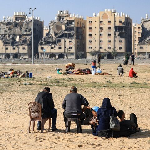 Residents of the Qatari-funded Hamad City residential complex in the Gaza Strip sit outside after  Israeli air strikes hit the development