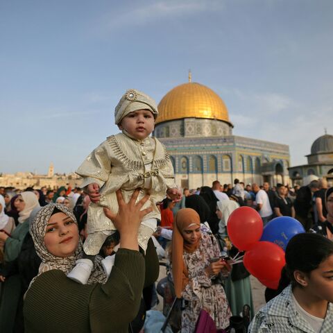 TOPSHOT - Muslims celebrate in front of the Dome of the Rock mosque after the morning Eid al-Fitr prayer, which marks the end of the holy fasting month of Ramadan, at the Al-Aqsa mosques compound in Old Jerusalem early on May 2, 2022. (Photo by AHMAD GHARABLI / AFP) (Photo by AHMAD GHARABLI/AFP via Getty Images)