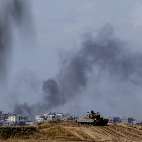 Smoke rises over Gaza as an Israeli tank takes position along the border with the Gaza Strip, southern Israel, May 13, 2024.