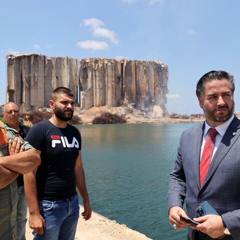 Lebanese Minister of Economy Amin Salam (R) vists the port of the capital Beirut, as a corner of the silos which were destroyed in a massive explosion on August 4, 2020, burns on July 14, 2022. - The fire at the port's blast-hit grain silos, at risk of collapse due to severe damage, ignited at the start of the month because of fermentation of remaining grain stocks paired with rising temperatures. (Photo by ANWAR AMRO / AFP) (Photo by ANWAR AMRO/AFP via Getty Images)