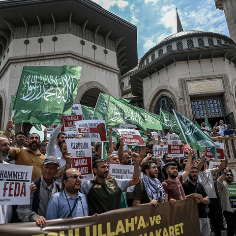 Protesters hold placards as they demonstrate against cartoonists of a satirical magazine following allegations that it had published a cartoon of the Prophet Mohammed, outside Taksim mosque in Istanbul on July 1, 2025.