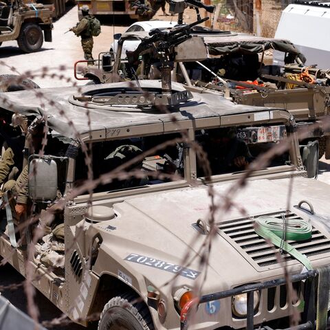 Israel military vehicles drive along the border fence with Syria, near the town of Majdal Shams, in the Israeli-annexed Golan Heights, July 17, 2025.
