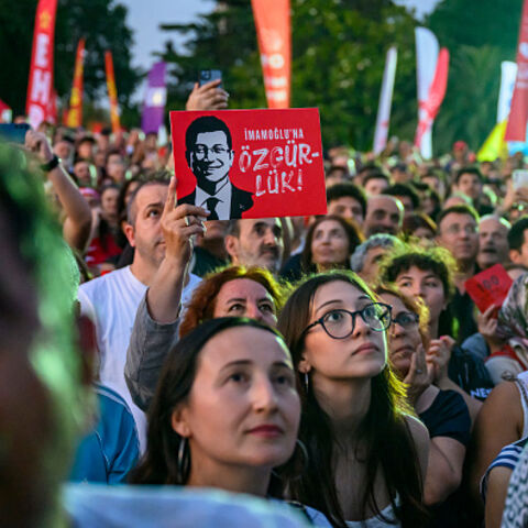 A protestor holds a placard of Istanbul's detained Mayor Ekrem Imamoglu as they listen to the leader of Turkey's main opposition Republican People's Party (CHP) Ozgur Ozel during a rally protesting the 100th day of his detention at Sarachane Square in Istanbul on July 1, 2025. (Photo by Yasin AKGUL / AFP) (Photo by YASIN AKGUL/AFP via Getty Images)