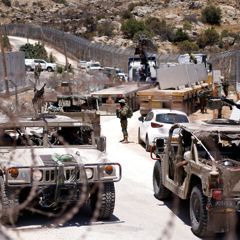 Israel military vehicles drive along the border fence into Israel, near the town of Majdal Shams, in the Israeli-annexed Golan Heights, July 17, 2025.