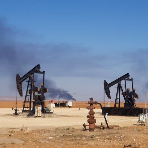 This picture shows pumpjacks in an oil field and smoke plumes rising in the background, following reported Turkish drone strikes near the town of al-Qahtaniyah in Syria's northeastern Hasakah province, close to the border with Turkey, on Nov. 23, 2022.