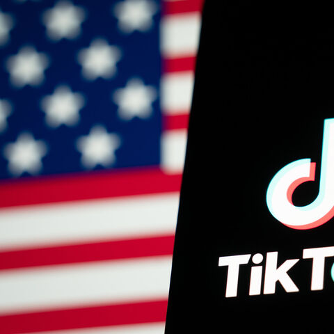 In this photo illustration, the TikTok logo and flag of the United States are seen on screens in Hong Kong, China, Jan. 18, 2025.