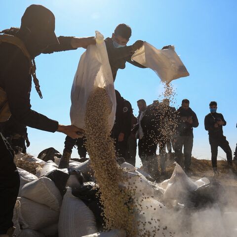 Members of Syria's new security forces empty sacks of Captagon into a ditch to burn them in a field on the outskirts of Damascus, on Jan. 19, 2025.