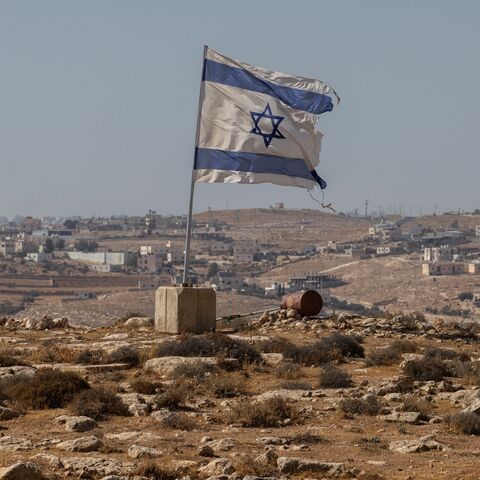 An Israeli flag flies along a highway near the settlement of Carmel on Aug. 4, 2025, in the South Hebron Hills of the West Bank. 