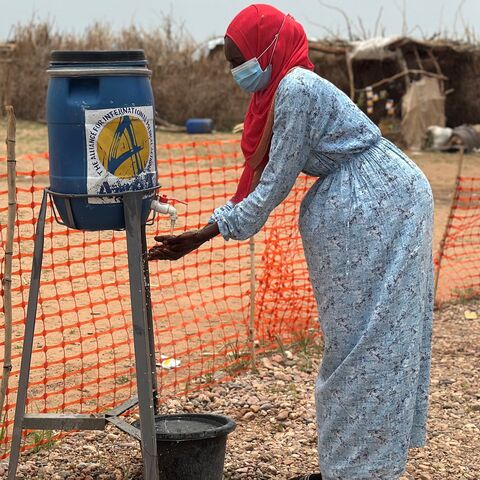 A woman washes her hands at the entrance of a cholera isolation center at the refugee camps of western Sudan, in Tawila in Darfur, on Aug. 12, 2025. 