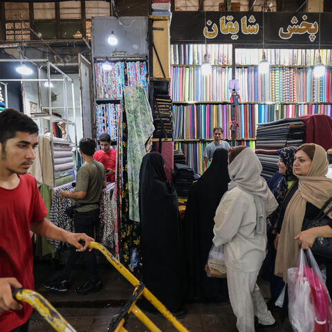 Iranians walk past shops in the Grand Bazaar in Tehran on Aug. 13, 2025.
