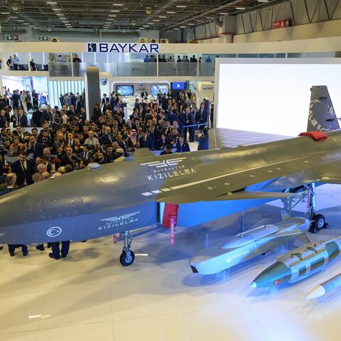 Visitors stand looking at the Bayraktar Kizilelma UCAV at the International Defence and Aerospace exhibition in Istanbul on Oct. 22, 2024.