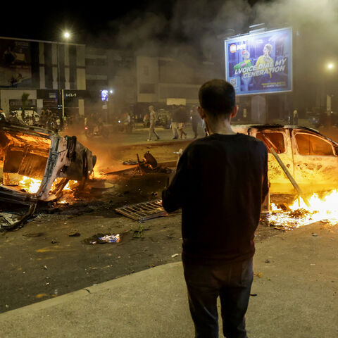 People look at police vehicles set on fire during a youth-led demonstration demanding reforms in the healthcare and education sectors in Sale on Oct. 1, 2025. 