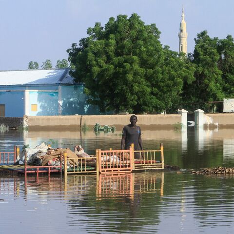 A resident stands by belongings to salvage in a pool of water due to the flooding of the Nile river in the Sudanese village of Wad Ramli north of Khartoum on Oct. 1, 2025.