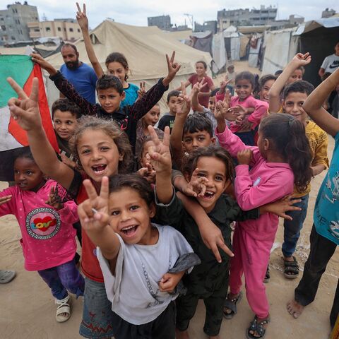 Palestinian children celebrate at a camp for displaced people in Nuseirat in the central Gaza Strip on Oct. 9, 2025, following news of a new Gaza ceasefire deal.