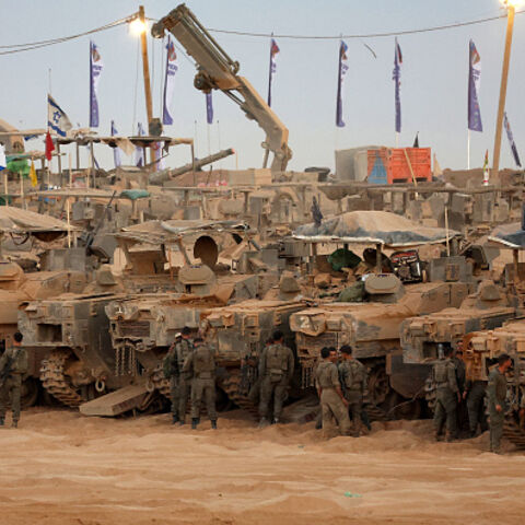 Israeli army soldiers gather near infantry-fighting vehicles (IFVs) at a position along the Israel-Gaza border fence on October 10, 2025. Gaza's civil defence agency said October 10 that Israeli forces have begun pulling back from parts of the territory, particularly in Gaza City and Khan Yunis. Israeli prime minister's office said that the government had "approved the framework" of a hostage release deal with Hamas, as both sides edged closer to ending more than two years of hostilities in Gaza. (Photo by 