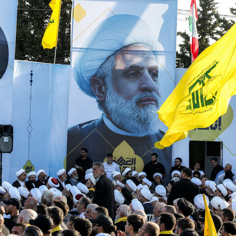 A large picture of Naim Qassem (C), current leader of the Lebanese Shiite movement Hezbollah, is displayed near another of the group's slain longtime leader Hassan Nasrallah during a ceremony marking the first anniversary of Israel's assassination of Nasrallah and other group leaders, in the town of Deir Qanoun al-Nahr near Tyre in southern Lebanon on September 27, 2025. The Iran-backed group, weakened by a deadly war with Israel last year, has organised a series of commemorative events to mark Nasrallah's 