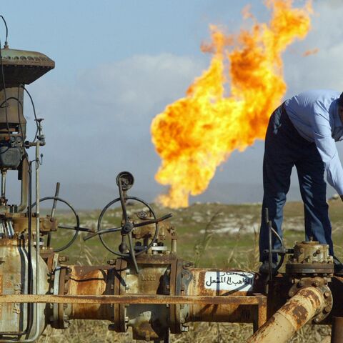 A worker turns a valve at the Shirawa oil field, where oil was first pumped in Iraq in 1927, outside the northern city of Kirkuk, Jan. 19, 2004.