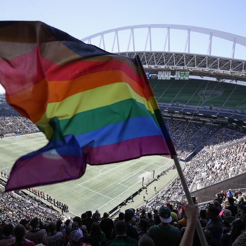 A fan waves a Pride flag before the soccer match between the Seattle Sounders and the Portland Timbers at Lumen Field, on June 3, 2023, in Seattle, Washington.
