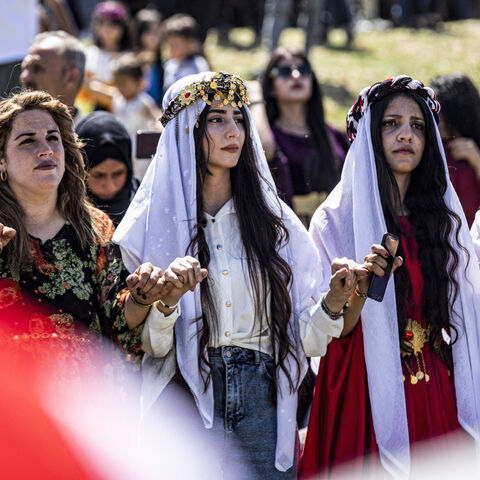 Syrian Yazidi women dressed in traditional clothing dance with other revelers during a ceremony marking the Yazidi New Year in the Kurdish village of Dogir near Amuda in northeastern Syria on April 17, 2024. 