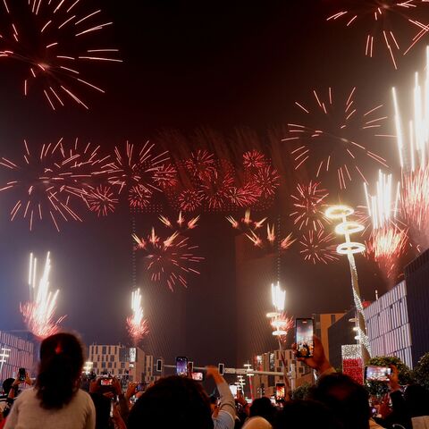 People gather to watch a fireworks and drone display during New Year's Eve celebrations in Doha early on Jan. 1, 2025. (KARIM JAAFAR/AFP via Getty Images)