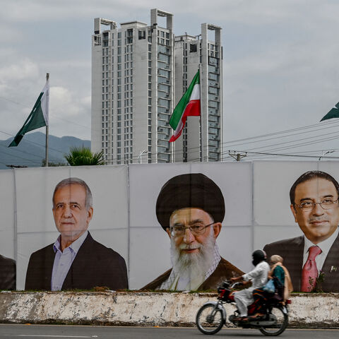 A motorcyclist rides past a banner with the portraits of (L-R) Pakistan's Prime Minister Shehbaz Sharif, Iran's President Masoud Pezeshkian, Iran's Supreme Leader Ayatollah Ali Khamenei and Pakistan's President Asif Ali Zardari, welcoming Iran's president during his state visit in Islamabad on August 2, 2025. (Photo by Farooq NAEEM / AFP) (Photo by FAROOQ NAEEM/AFP via Getty Images)