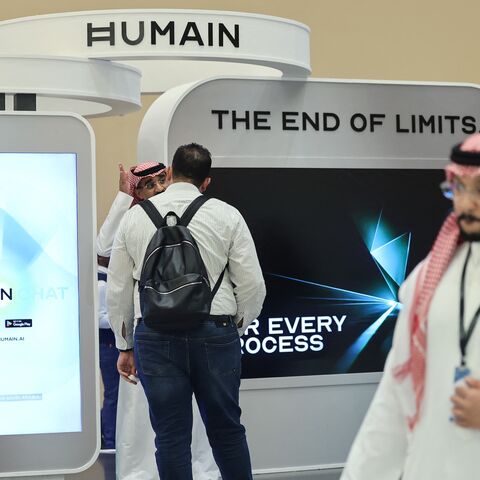 Guests stand at the booth of Saudi AI company Humain during the Future Investment Initiative conference in Riyadh on Oct. 29, 2025.