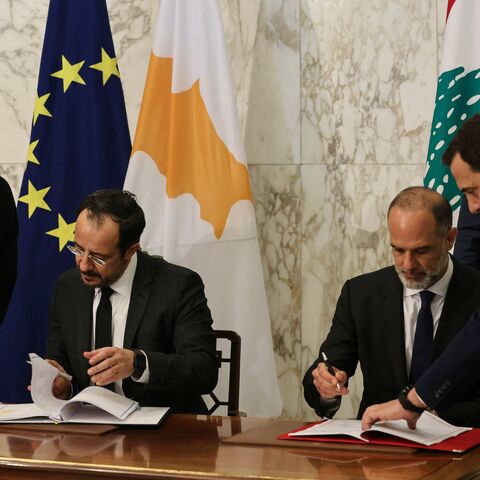 Cypriot President Nikos Christodoulides signs documents with Lebanese Minister of Public Works and Transport Fayez Rasamny, as Lebanon's president, Joseph Aoun, looks on during an agreement signing ceremony at the presidential palace of Baabda, east of Beirut, on Nov. 26, 2025. 