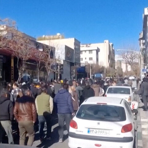 People walk down the street, chanting in Farsi, "Reza Shah, rest in peace", in Tehran, Iran, in this still image obtained from a social media video released on December 30, 2025. Social Media/via REUTERS