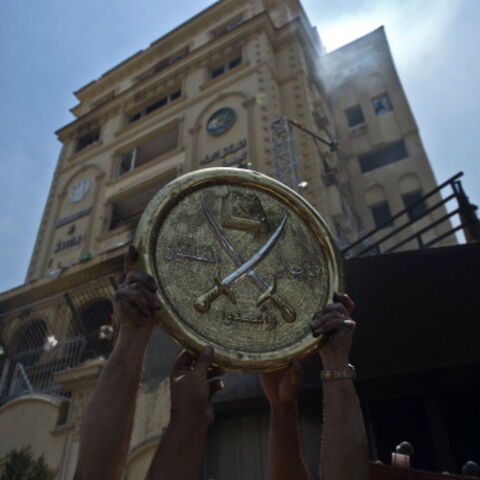 Egyptians hold a plaque of the Muslim Brotherhood emblem which was removed from the party's burnt headquarters in the Moqattam district of Cairo on July 1, 2013 after it was set ablaze by opposition demonstrators overnight. Egypt's opposition gave Islamist Mohamed Morsi a day to quit or face civil disobedience after deadly protests demanded the country's first democratically elected president step down after just a year in office. AFP PHOTO / KHALED DESOUKI (Photo credit should read KHALED DESOUKI/AFP via G