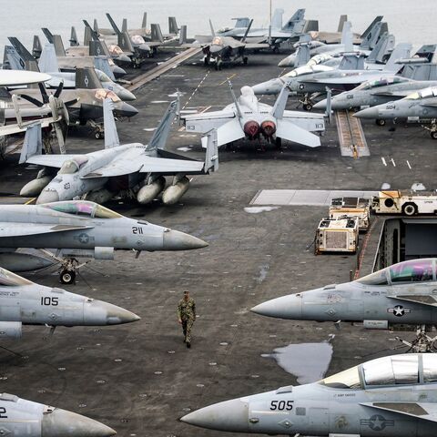 A US Navy officer walks past fighter jets parked on the flight deck of the Nimitz-class aircraft carrier USS Abraham, Kuala Lumpur, Nov. 26, 2024