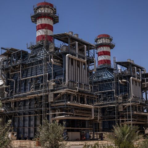 Workers walk past the gas turbine and heat recovery system of Syria's largest power plant on June 12, 2025, in Deir Ali, Syria.