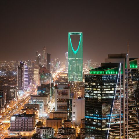 Aerial view of Riyadh at night with illuminated modern skyscrapers and busy streets under a clear dark sky, Al Olaya street.