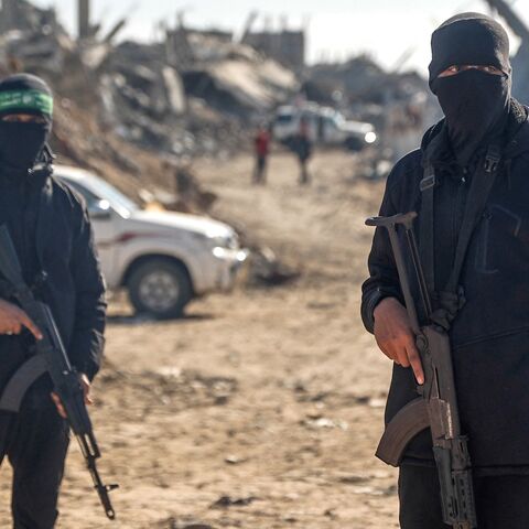 Palestinian Hamas militants secure the area as Egyptian workers, accompanied by members of the International Committee of the Red Cross, search for the last two remaining bodies of hostages from under the rubble of the Jabalia refugee camp, in the northern of Gaza Strip on Dec. 1, 2025. 