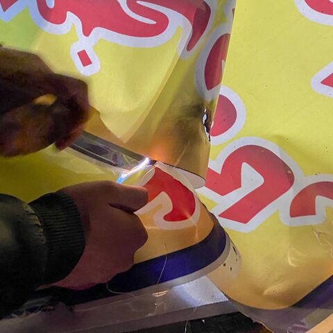 A person uses a lighter to set fire to a banner during demonstrations in Hamedan, Iran, on Jan. 1, 2026. 