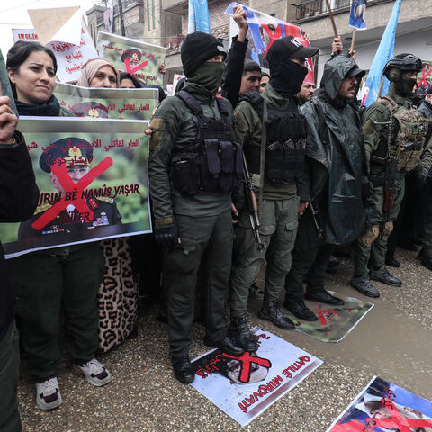 Members of the Kurdish forces hold a portrait of Turkish Defense Minister Yasar Guler which reads "Shame on the killers of innocents in the Sheikh Maqsoud neighborhood" during a protest by Syrian Kurds against violence they say was committed by Syrian government forces during recent clashes in Aleppo's Kurdish neighbourhoods, in the Kurdish-controlled northeastern city of Qamishli on Jan. 13, 2026. 