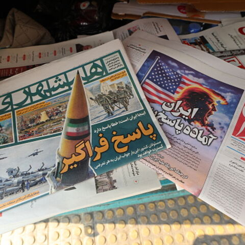 A photograph shows newspapers, one of them (R) with a headline in Persian reading "Iran is ready for a big response", at a kiosk in Tehran on January 27, 2026. (ATTA KENARE / AFP via Getty Images)