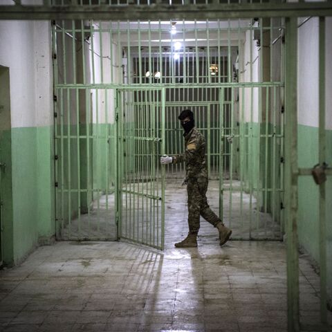 A member of the Syrian Democratic Forces (SDF) stands guard in a prison where men suspected to be afiliated with the Islamic State (IS) group are jailed in northeast Syria in the city of Hasakeh on Oct. 26, 2019. 