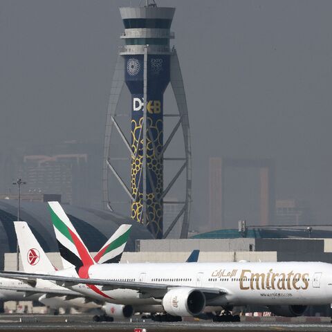 An Emirates Boing 777-300ER is pictured in front an air traffic control tower at Dubai International Airport in Dubai, on Jan. 30, 2023.