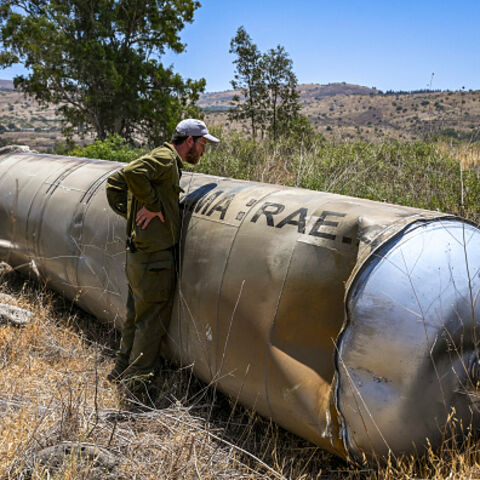 Members of the Israeli security forces check the apparent remains of an Iranian ballistic missile lying on the ground in the Golan Heights, Northern Israel, on Thursday, June 19, 2025. (Photo by Michael Giladi / Middle East Images via AFP) (Photo by MICHAEL GILADI/Middle East Images/AFP via Getty Images)