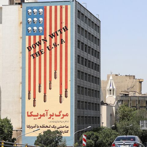 Commuters drive along a bridge near a building bearing a landmark anti-US mural in Tehran, on June 22, 2025. 