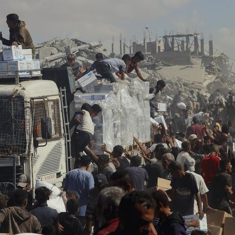People walk through a heavily damaged street in Khan Younis, southern Gaza Strip, on Oct. 12, 2025.