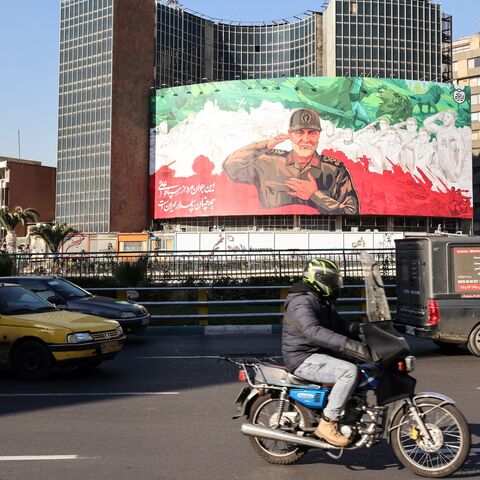 Iranians ride their motorbike past a huge banner of former Iran Islamic Revolutionary Guard Corps (IRGC) Quds Force commander Qasem Soleimani ahead of the sixth anniversary of his assassination, in Tehran, Dec. 31, 2025. 