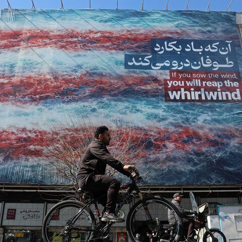 A cyclist rides past an anti-US billboard installed on a building along a street in Tehran on Feb. 26, 2026.