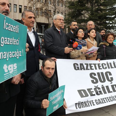 Journalists gather outside the Ankara courthouse on March 10, 2020 behind a banner reading in Turkish "journalism is not crime," to protest over jailing of journalists, sparked by the recent arrest of OdaTV's news director and a journalist's report on the funeral of a Turkish intelligence officer apparently killed in Libya. 